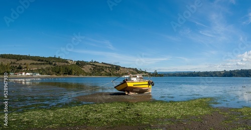 Yellow boat near the water in Chiloe Island in Chile on a sunny day photo