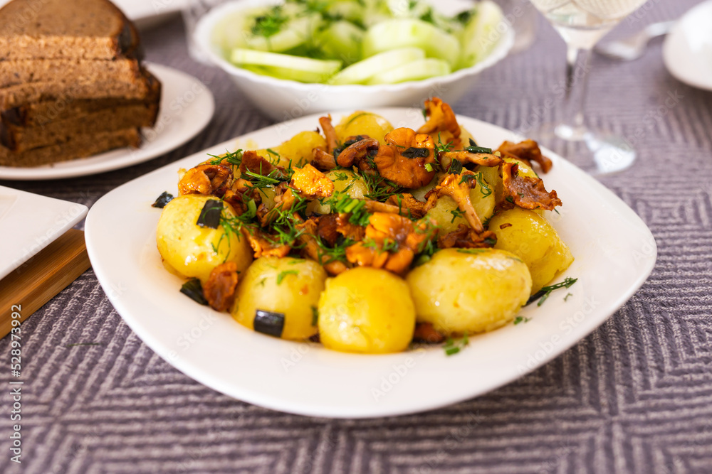 baked potatoes with chanterelles, served with herbs on white plate baked potatoes with chanterelles, served with herbs on white plate