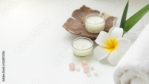 Still life spa setting with pink stone aroma scent candle and plumeria flower. Thai spa massage. Spa treatment cosmetic beauty. Aromatherapy care relax wellness. Aroma and salt scrub healthy lifestyle