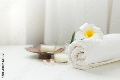 Still life spa setting with pink stone aroma scent candle and plumeria flower. Thai spa massage. Spa treatment cosmetic beauty. Aromatherapy care relax wellness. Aroma and salt scrub healthy lifestyle