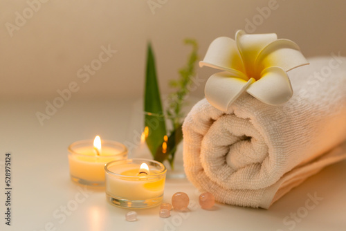 Still life spa setting with pink stone aroma scent candle and plumeria flower. Thai spa massage. Spa treatment cosmetic beauty. Aromatherapy care relax wellness. Aroma and salt scrub healthy lifestyle