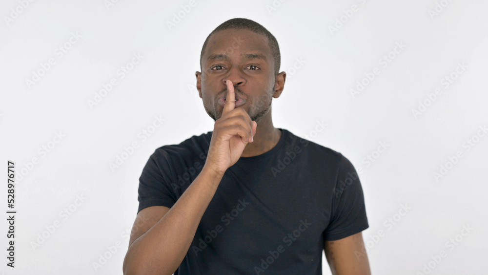 Silence Please, Young African Man with Finger on Lips on White Background Silence Please, Young African Man with Finger on Lips on White Background