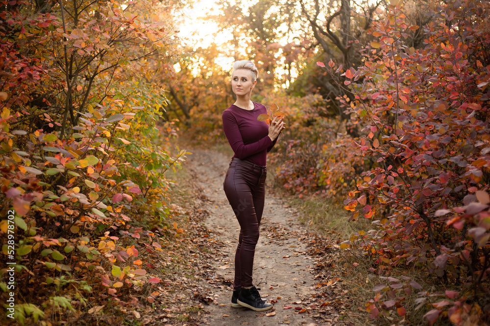 Autumn woman with autumn leaves. Portrait of a charming and lovely girl. Happy woman enjoying the autumn. Autumn woman with autumn leaves. Portrait of a charming and lovely girl. Happy woman enjoying the autumn.