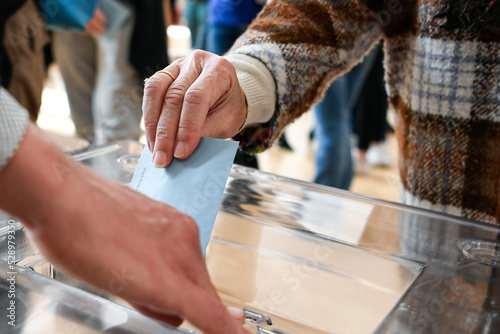 Illustration picture shows a person voting with a ballot paper in its envelope just before being placed in the ballot box photo