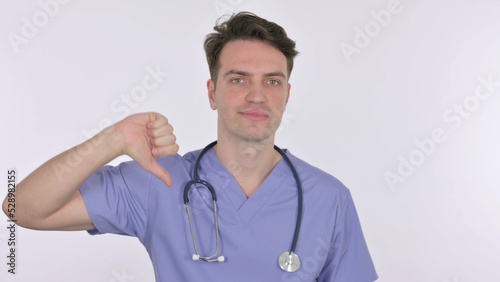 Thumbs Down by Young Doctor on White Background © stockbakers
