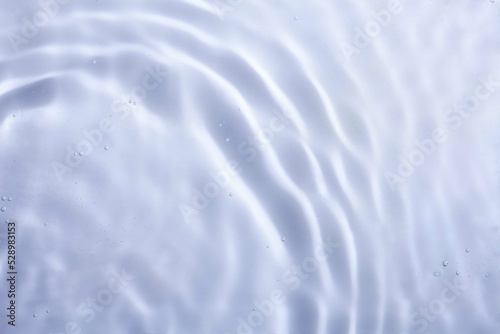 Soft focus lite purple blue gray cosmetic moisturizer floral water, micellar toner, or emulsion abstract background. Reflections of scattered sun texture.