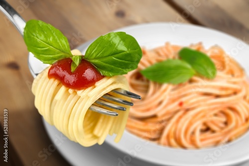 Classic Italian Pasta Spaghetti on plate with wooden table background. Simple and easy vegetarian dish.