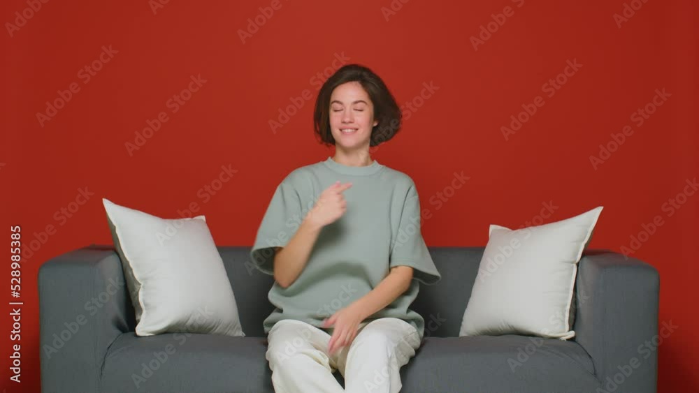 Confident proud cool young girl pointing by fingers on herself sitting on sofa. Self-love, choose me concept Confident proud cool young girl pointing by fingers on herself sitting on sofa. Self-love, choose me concept