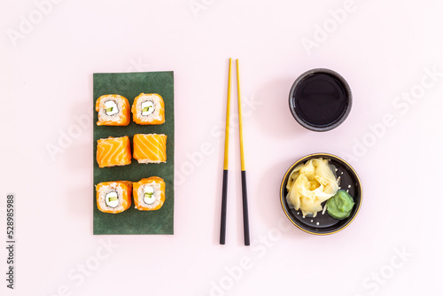 Sushi rolls set with salmon eco served on green papper plate, top view