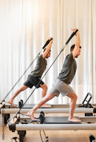 Wallpaper Mural Sportsmen exercising on pilates reformer beds Torontodigital.ca