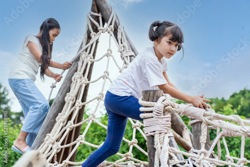 seven-year-old girl and her friends go camping in the playground for rope guns. kids adventure concept photo