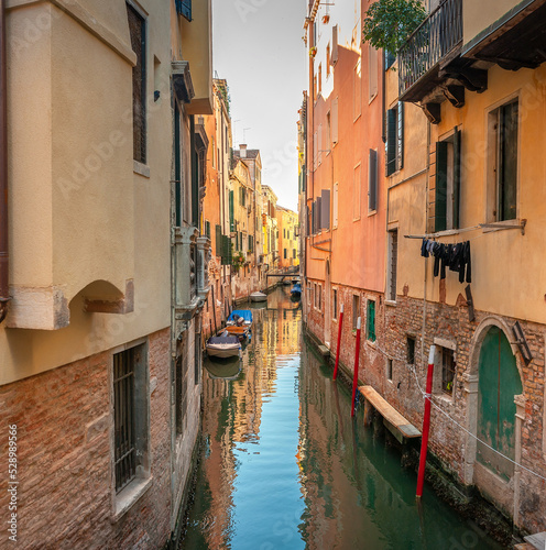 Obraz na płótnie View on the narrow cozy streets of the canals with parked boats in Venice, Italy. Architecture and landmark of Venice. w salonie