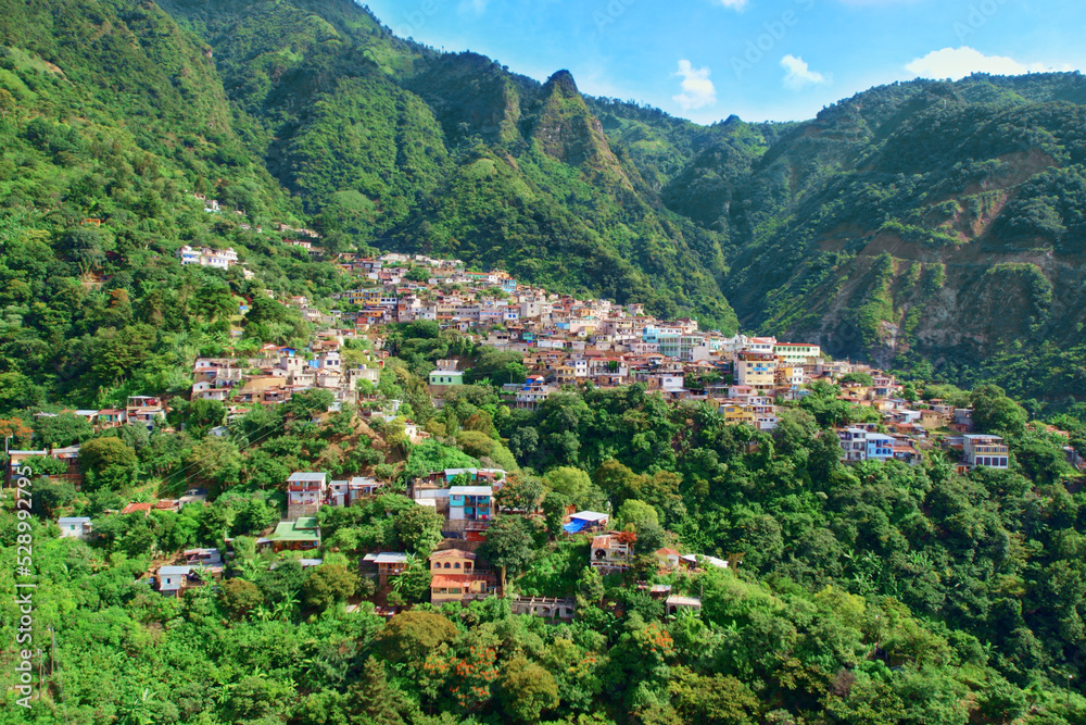 Santa Cruz La Laguna, Solola, Guatemala. Aerial Drone Shot Of Colorful Mountainside Village On Side Of A Mountain Surrounded By Jungle Rainforest Trees And Foliage In Lake Atitlan, Central America.