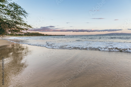Maui Hawaii beach coastline of sand, sun, and blue water with crashing