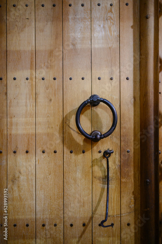 Fragment of a wooden door with a ring and a hook of the Dmitrievsky Cathedral in Vladimir, Russia photo