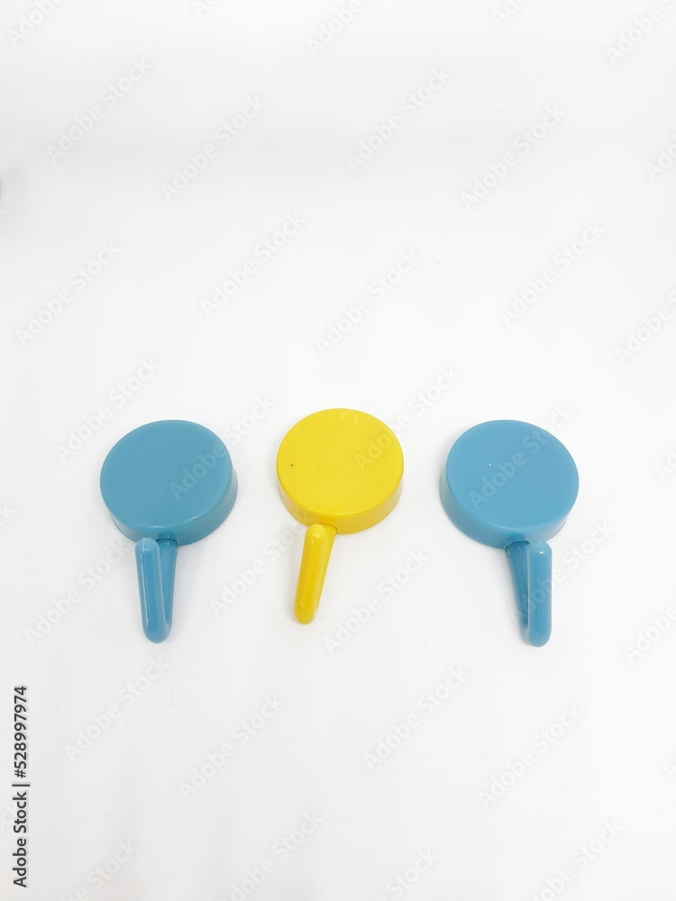Isolated white photo of three round coat hangers with blue and yellow colors. Isolated white photo of three round coat hangers with blue and yellow colors.