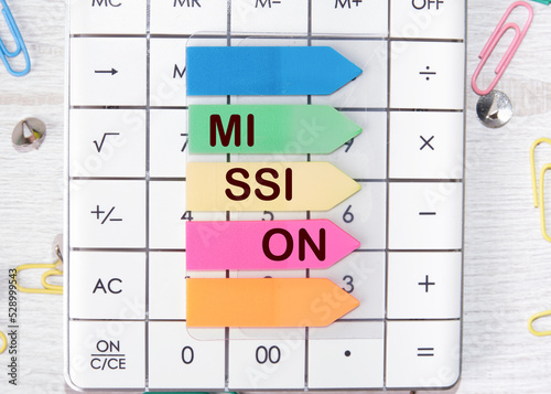The inscription mission on colored stickers lying on the calculator, as a reminder of something important and urgent