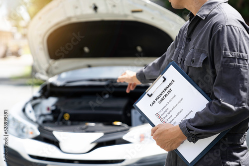 car service and maintenance. Services car engine machine concept, Automobile mechanic repairman checking a car engine with inspecting writing to the clipboard the checklist for repair machine