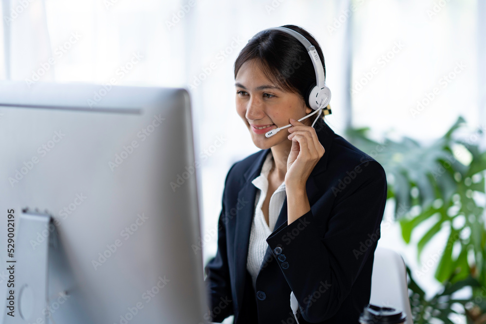 female operator Asia works with computers and headphones in the office. female operator Asia works with computers and headphones in the office.