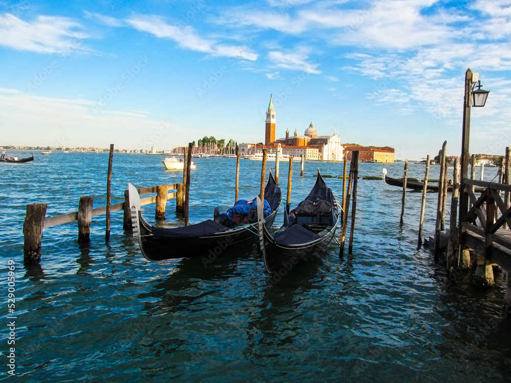 Two gondolas in the sea on the background of San Giorgio Maggiore. Bright colorful photo