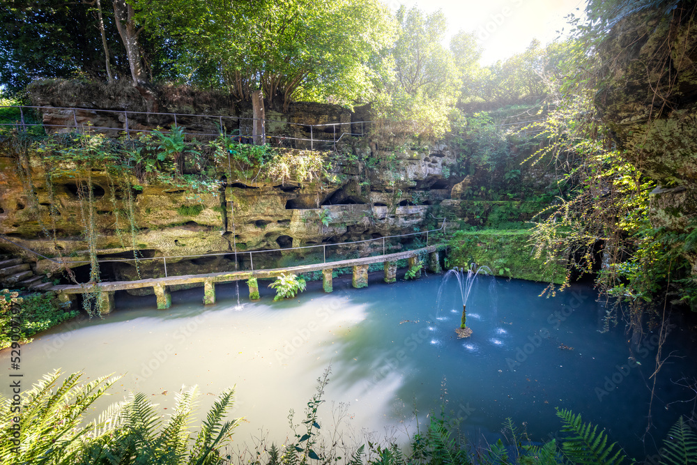 Felsenweiher Ernzen mit Nischen und Höhlen inmitten von Felsen und grünen Pflanzen