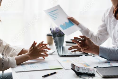 Business team together to make investment plan at the meeting. Close-up of business advisor pointing to graph and chart analyzing company financial report.