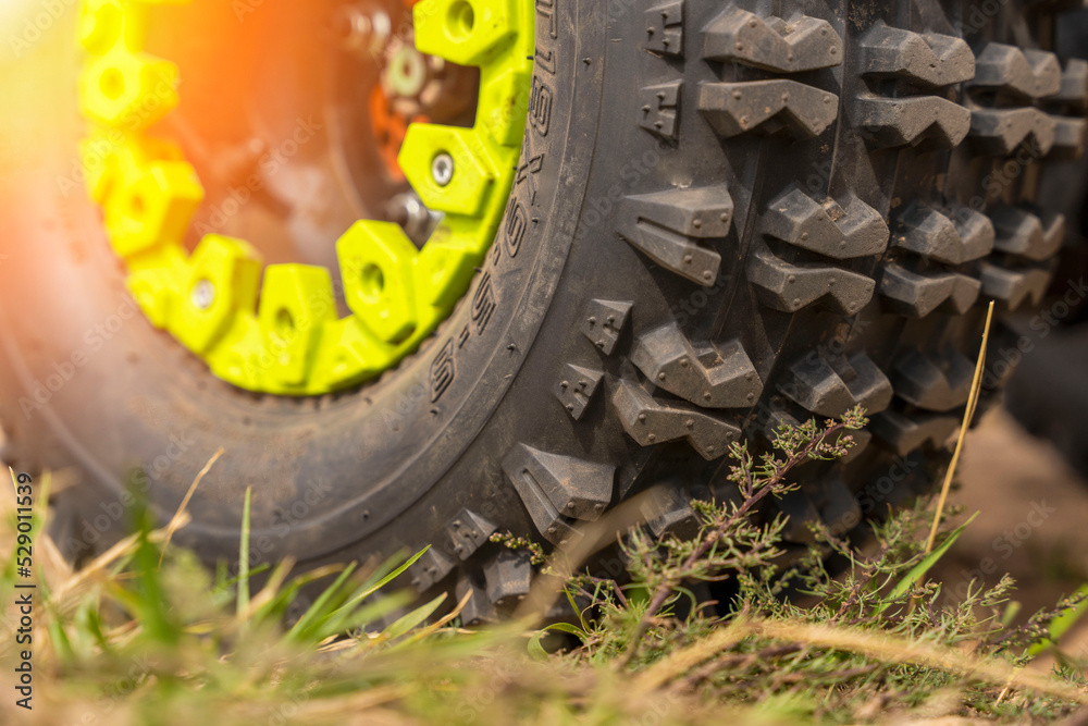 Close-up of the ATV wheel on sandy ground.