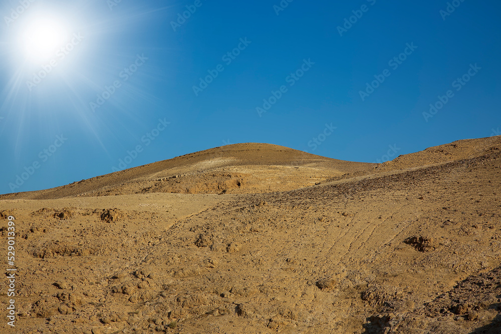Sand dunes in Judean Desert of the Dead Sea, Israel. Mountain fantasy landscape on sky background. Sunny sky over salty cliffs, large salt mountains Sodom and Gomorrah. Judean desert, salt layers