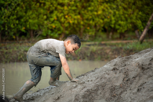 Little boys have fun playing in the mud in the community fields