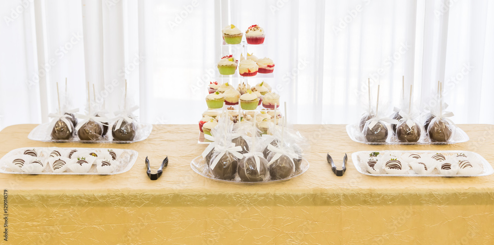 Chocolate covered candied apples, and cupcake pastries displayed for desert at a breakfast brunch celebration.