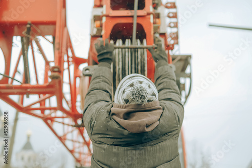 Back view of a worker at the hook of a truck crane