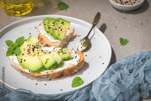 Healthy toast with avocado cream cheese and wheat bread on a plate. Delicious snacks and avocado sandwiches. Food composition, tasty Italian meal.