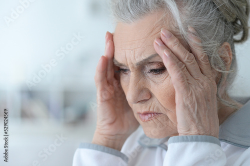 Portrait of sad senior woman with headache