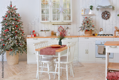 Interior of a light white ?hristmas kitchen with red decor elements in the Scandinavian style. Christmas decorations. Breakfast.Merry Christmas and Happy New Year!