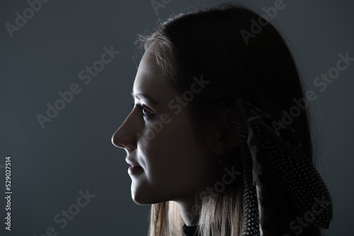 Fotografia Close-up woman dark profile portrait in low light studio shot