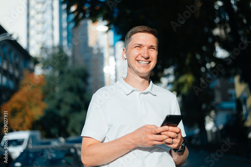 Outdoor portrait of a modern young man with a mobile phone in the street.