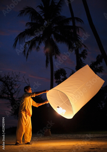 Man Holding Paper Khom Loy  Lantern, Koh Samui, Thailand.  photo
