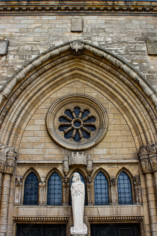 Beautiful Stained Window at Madonna with Child Statue, Surrounded by Several Saint Carvings, on the Entrance of the Notre Dame Cathedral in Luxembourg City, Luxembourg