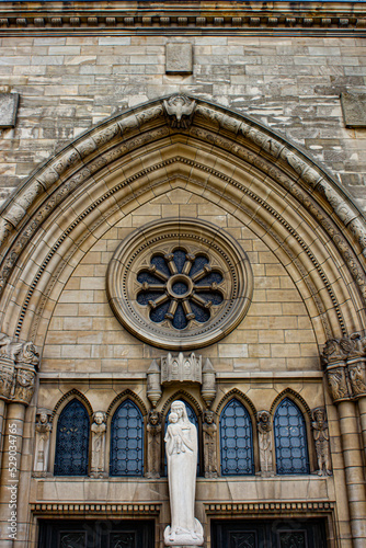 Beautiful Stained Window at Madonna with Child Statue  Surrounded by Several Saint Carvings  on the Entrance of the Notre Dame Cathedral in Luxembourg City  Luxembourg