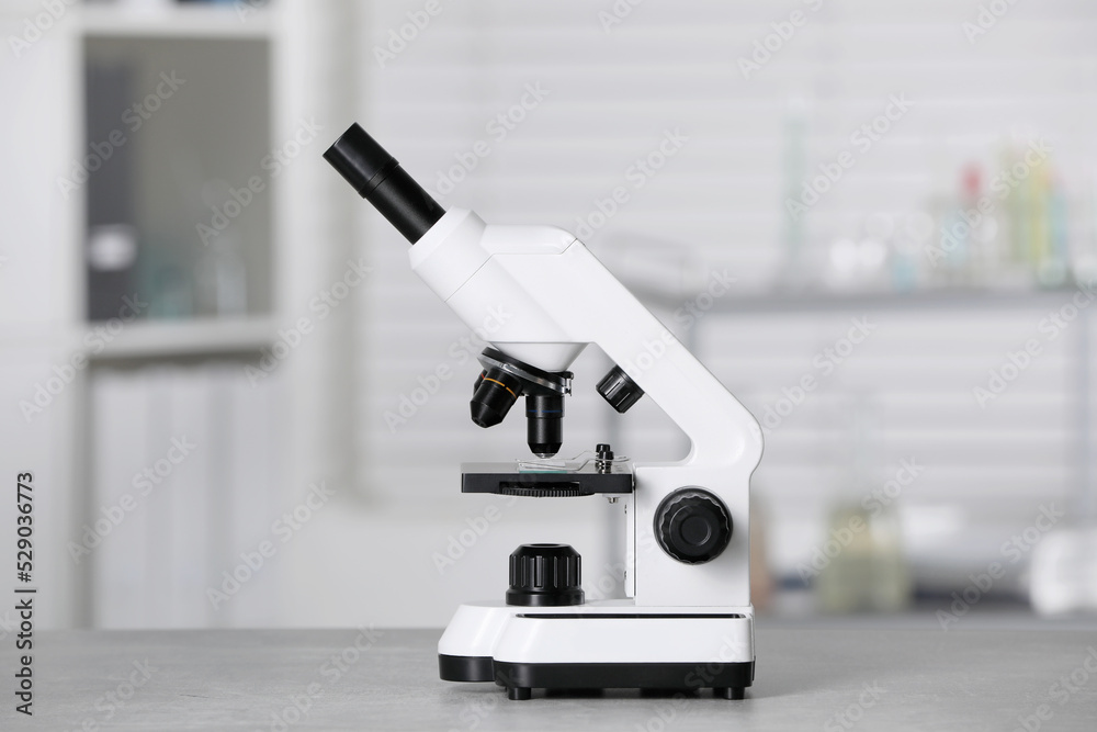 Modern medical microscope on grey table in laboratory Modern medical microscope on grey table in laboratory