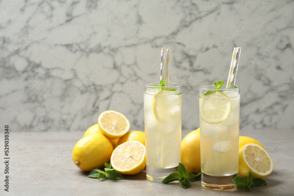 Fototapeta premium Natural lemonade with mint and fresh fruits on light grey table. Summer refreshing drink