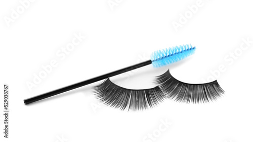 Fake eyelashes and brush on white background