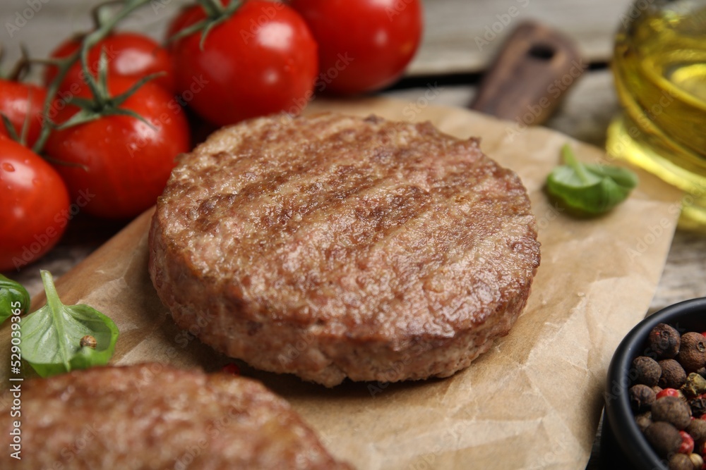 Tasty grilled hamburger patties with basil served on table, closeup Tasty grilled hamburger patties with basil served on table, closeup