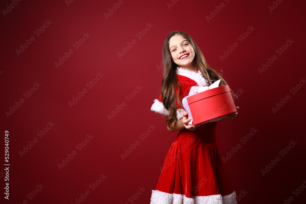 Beautiful little girl in festive costume hold gift box. christmas decoration. holiday. fun Beautiful little girl in festive costume hold gift box. christmas decoration. holiday. fun