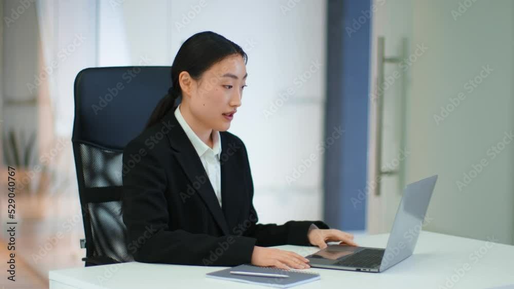 Young positive asian woman manager video chatting with colleagues on laptop, waving hand to team at office, empty space Young positive asian woman manager video chatting with colleagues on laptop, waving hand to team at office, empty space