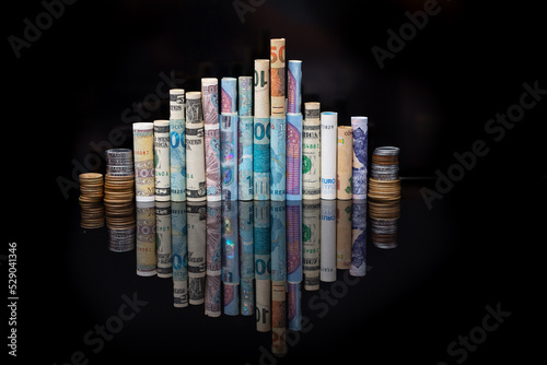 Banknotes of several international currencies rolled up side by side as if they were buildings of a city