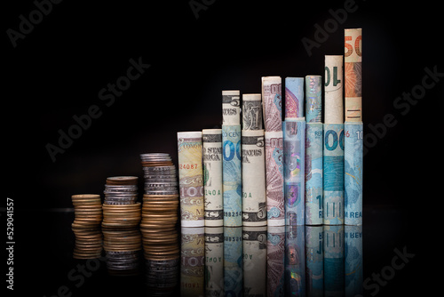 Banknotes of several international currencies rolled up side by side as if they were buildings of a city