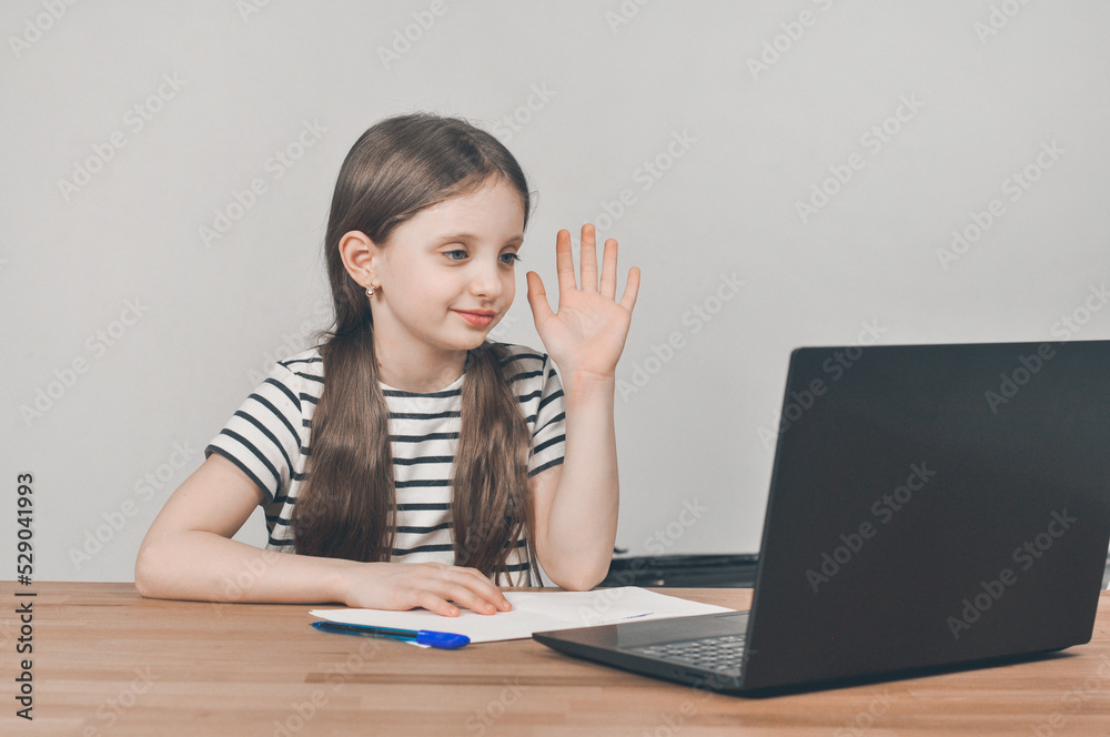 European girl with a laptop. Sitting at the table doing homework. Online learning European girl with a laptop. Sitting at the table doing homework. Online learning
