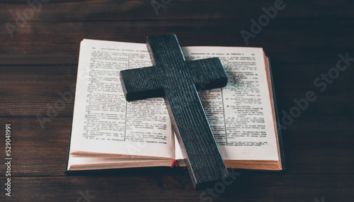 Open Bible. Cross crucifixion. The concept of God's love. On a wooden background.