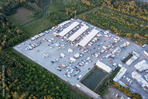 Aerial view of the goods warehouse. Logistics center in the industrial area of the city with a lot of cars